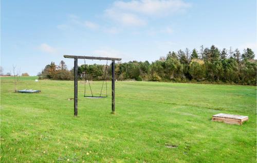 an empty park with a swing set in a field at Holiday Home Baldersvej Askeby Ix in Askeby