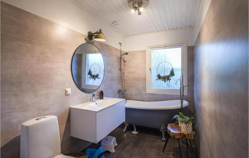 ein Badezimmer mit einer Badewanne, einem Waschbecken und einer Badewanne in der Unterkunft Beautiful Home In Slite With Kitchen in Slite