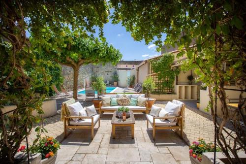 a patio with a couch and chairs and a table at La Chasse au Bonheur in Rieux-Minervois