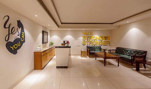a lobby with a waiting room with a couch and a counter at Hotel Saket 27 in New Delhi