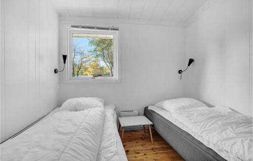 two beds in a white room with a window at Holiday Home Græsted With Fireplace 02 in Græsted