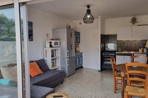 un salon et une cuisine avec un canapé et une table dans l'établissement Résidence le Formentor, à Leucate