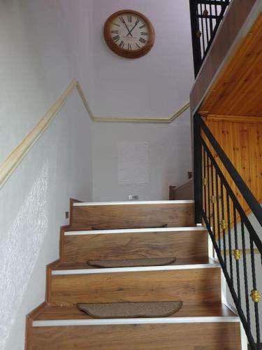 a clock on the wall next to a stairway at Shkodra 27 center house in Shkodër