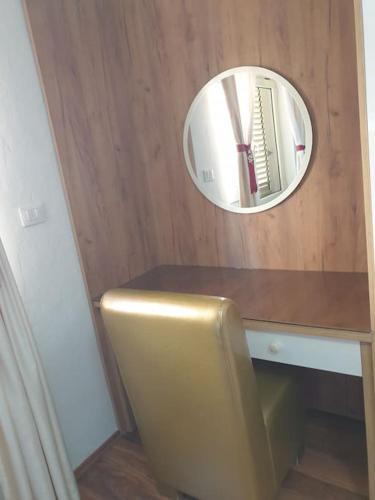 a mirror on a wooden wall above a desk with a chair at Shkodra 27 center house in Shkodër