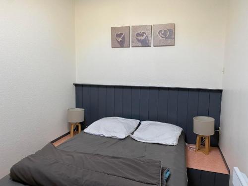 - une petite chambre avec un lit et deux chaises dans l'établissement Appartement Cosy - Les Ecureuils, à Arès