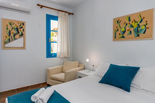 a bedroom with a bed and a chair at Eleni Villas in Hersonissos