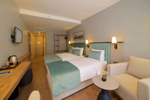 a hotel room with a large bed and a couch at Days Inn by Wyndham Istanbul Arnavutkoy in Istanbul