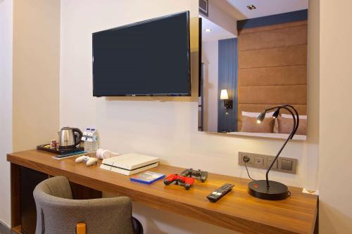 a room with a desk with a television on the wall at Days Inn by Wyndham Istanbul Arnavutkoy in Istanbul