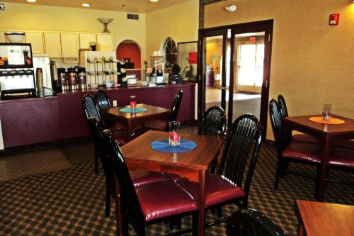 een restaurant met houten tafels en stoelen en een bar bij Travelodge by Wyndham Carlsbad NM in Carlsbad