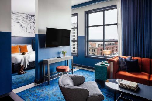 um quarto de hotel com uma cama, um sofá e uma televisão em Dream Nashville, by Hyatt em Nashville