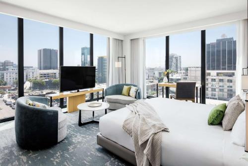 a bedroom with a large bed and a large window at Dream Hollywood, Part Of Hyatt in Los Angeles