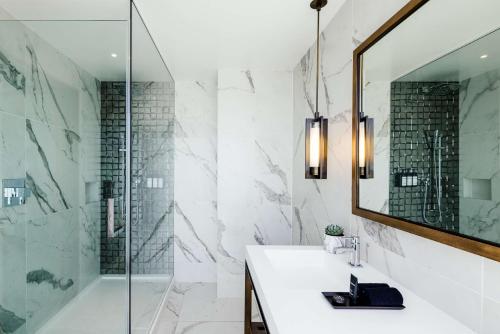 a bathroom with a shower and a sink and a mirror at Dream Hollywood in Los Angeles