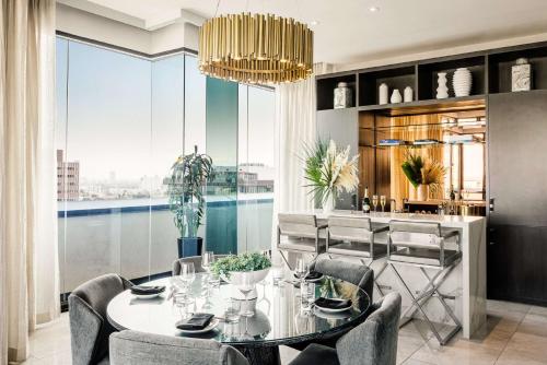 a dining room with a glass table and chairs at Dream Hollywood, Part Of Hyatt in Los Angeles