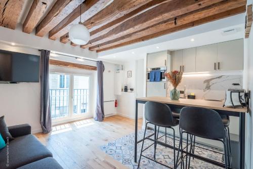 une cuisine et un salon avec une table et des chaises dans l'établissement Le Petit Rex, à Paris