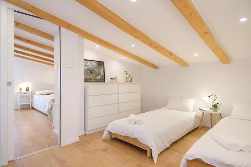 2 camas en un dormitorio con paredes blancas y vigas de madera en Holiday home Country retreat, en Višnjan