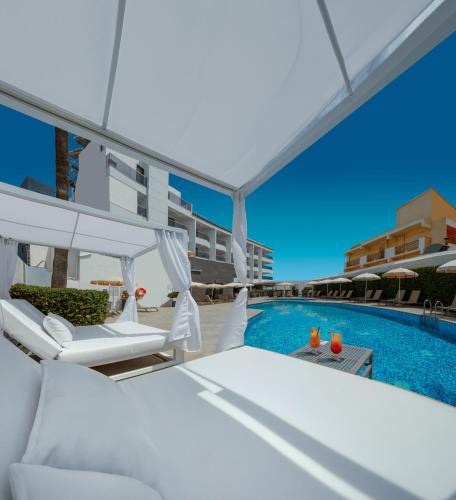 a view of a swimming pool with two lounge chairs and a swimming pool at Hotel RH Portocristo & Wellness in Peniscola
