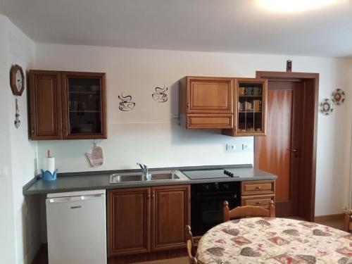 una cocina con armarios de madera y fregadero en Appartamento Vacanze da Jolanda, en Tarvisio