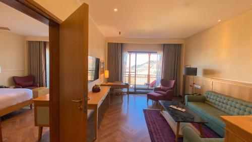 a hotel room with a bed and a couch at Taj Theog Resort & Spa Shimla in Shimla
