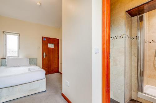 - une chambre avec un lit et une douche dans l'établissement London Star Hotel, à Londres
