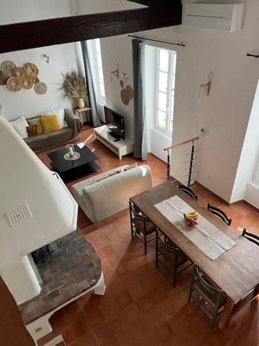 un salon avec une table et une cheminée dans l'établissement Jolie maison de village à Grimaud, à Grimaud