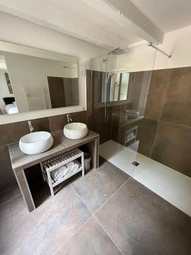 une salle de bain avec deux lavabos et un grand miroir dans l'établissement Jolie maison de village à Grimaud, à Grimaud