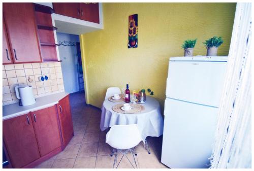 a small kitchen with a table and a refrigerator at Color24 Apartament VI in Stalowa Wola