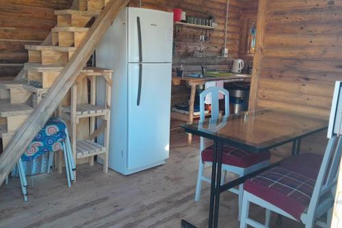 una cocina con nevera y una mesa en una cabaña en Los Cardones Tiny House en Potrerillos