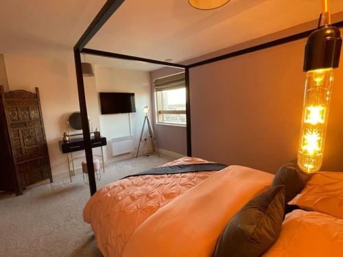 a bedroom with two beds and a television in it at Waterfront 2 bed apartment with views over Ipswich in Ipswich