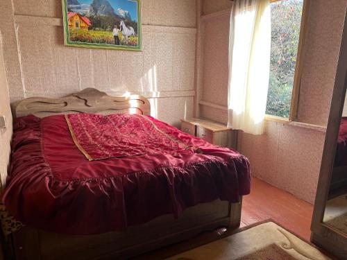 ein rotes Bett in einem Zimmer mit Fenster in der Unterkunft NIKATOLO - HOTEL GUESTHOUSE 