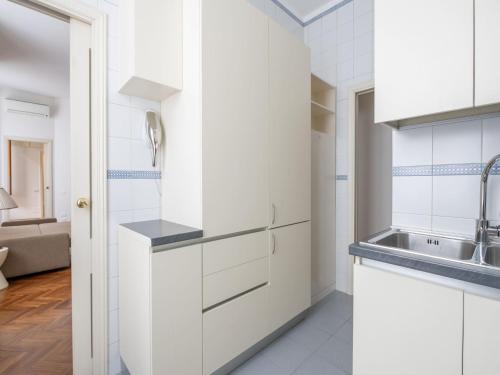 una cocina con armarios blancos y fregadero en The Best Rent - Gorgeous two-bedroom apartment in Porta Nuova district, en Milán