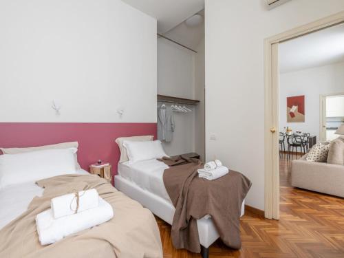 a bedroom with two beds and a couch at The Best Rent - Gorgeous two-bedroom apartment in Porta Nuova district in Milan