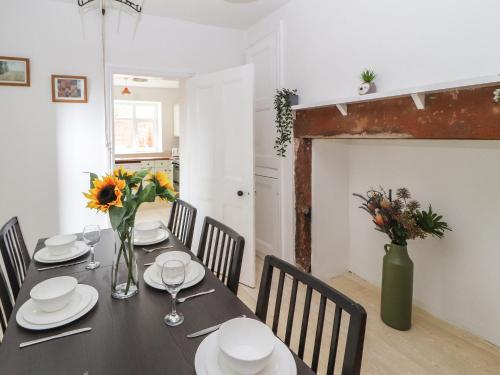 a dining room with a black table with flowers on it at 7 Lonsdale Terrace in Penrith