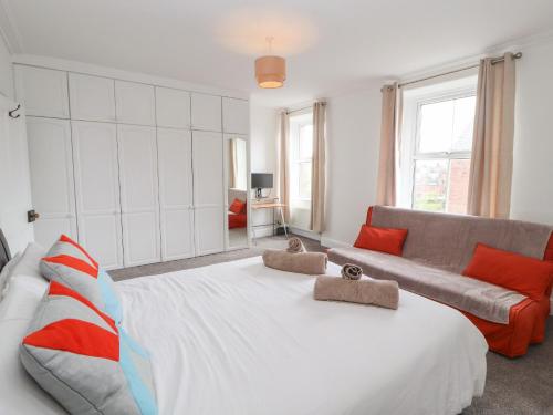 a bedroom with a large bed and a couch at 7 Lonsdale Terrace in Penrith
