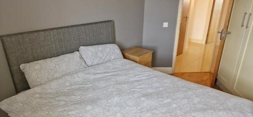 a bedroom with a bed with a gray bedspread at Two Bedroom Self Catering Apt. The Hawthorn's. Sligo in Sligo