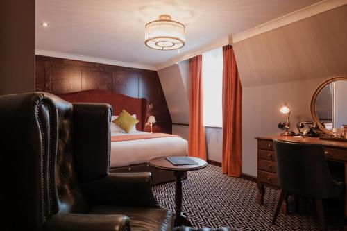 a hotel room with a bed and a desk and a chair at The Sanctuary House Hotel in London