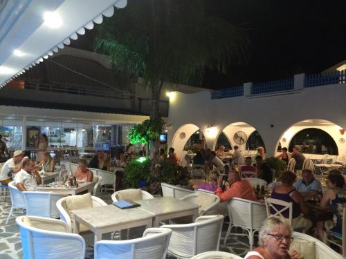 a group of people sitting at tables in a restaurant at Romantza Mare in Kallithea Rhodes