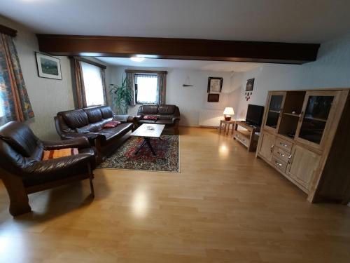 a living room with leather couches and a coffee table at Haus Hildegard in Tauplitz