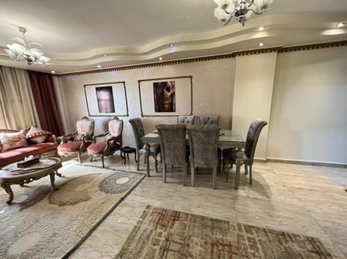 a living room with a table and chairs and a couch at شقه سكنيه فى مدينتى in Madinaty