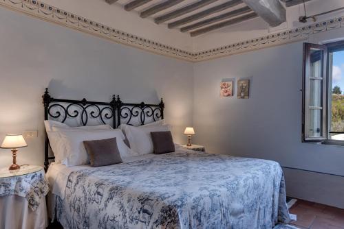 a bedroom with a bed with a blue and white bedspread at Agriturismo Nobile in Montepulciano