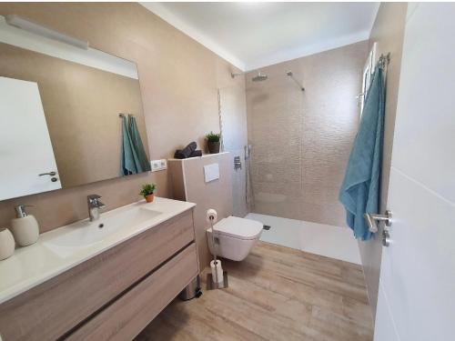 een badkamer met een wastafel, een toilet en een spiegel bij Aptos dOr in Cala d´Or