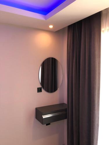 ein Bad mit einem runden Spiegel und einem Vorhang in der Unterkunft Erikli suit home in Erikli