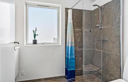 a bathroom with a shower and a window at Nice Home In Harbore With Sauna in Harboør