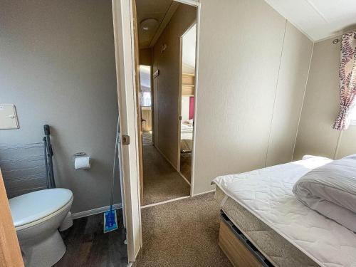 a small bathroom with a toilet and a shower at Modern Caravan With Decking At Azure Seas Along The Suffolk Coast Ref 32065az in Lowestoft