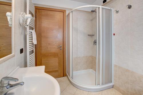 La salle de bains est pourvue d'une douche et d'un lavabo. dans l'établissement Chalet Anna Rododendro, à Livigno