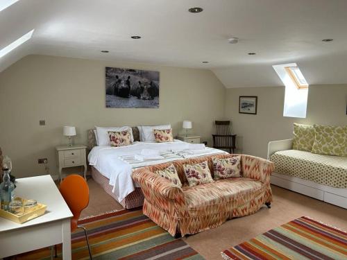 a bedroom with a large bed and a couch at The Wickerman Granary in Kirkcudbright