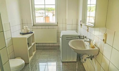 a white bathroom with a sink and a toilet at Appartementhaus Greta im Ostseebad in Ostseebad Sellin