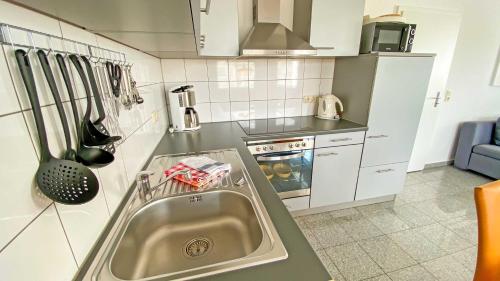 a kitchen with a sink and a stove at Appartementhaus Greta im Ostseebad in Ostseebad Sellin