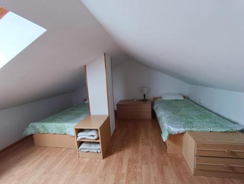 a attic room with two beds and a mirror at Studio Apartmani Zorić in Šilo