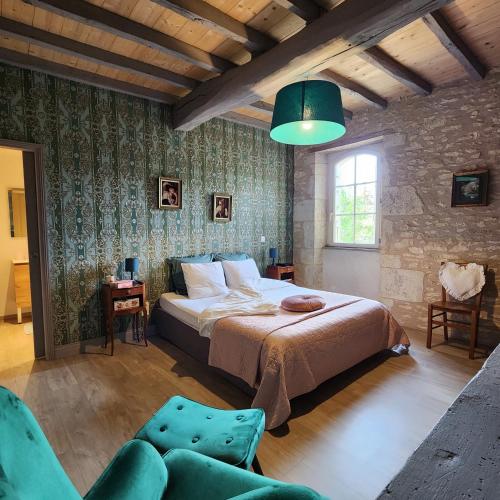 une chambre avec un grand lit et un mur en pierre dans l'établissement Presbytère d'Arpentian, à Jégun