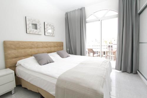 Un dormitorio con una cama grande y una ventana grande. en Casa grande familiar con 4 terrazas, en Las Palmas de Gran Canaria